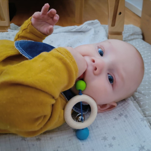 Baby nimmt Mobile in den Mund