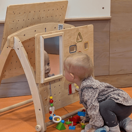 Baby guckt in den Spiegel